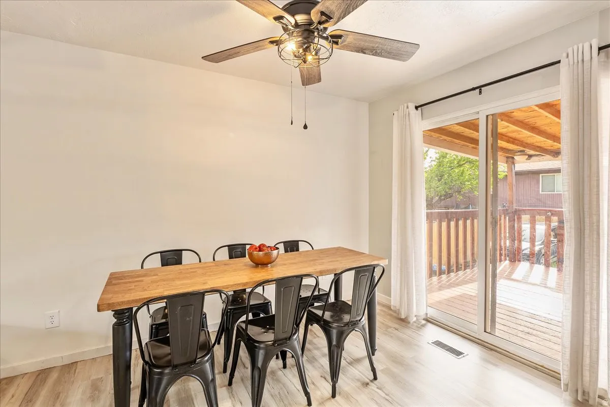 Dining area with light wood-style flooring and ceiling fan