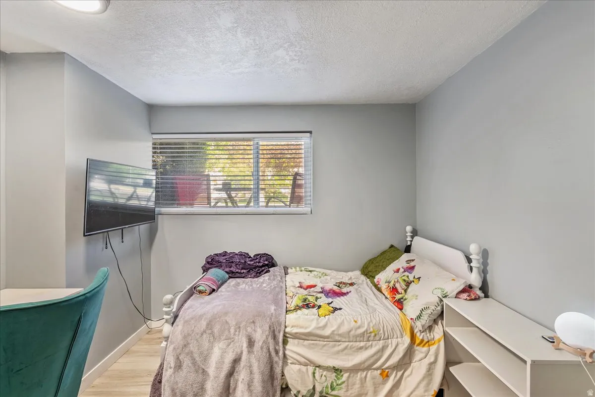 Bedroom with a textured ceiling and wood finished floors