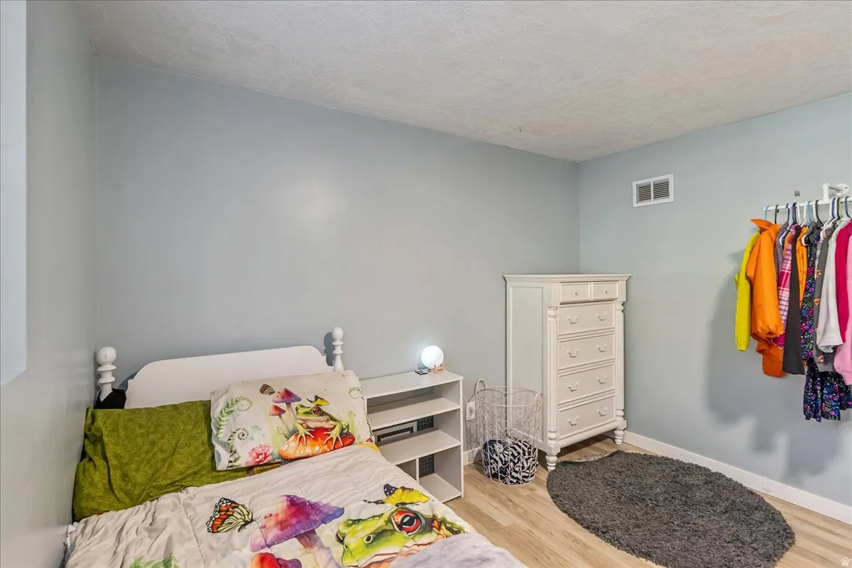 Bedroom featuring light wood-type flooring and a textured ceiling