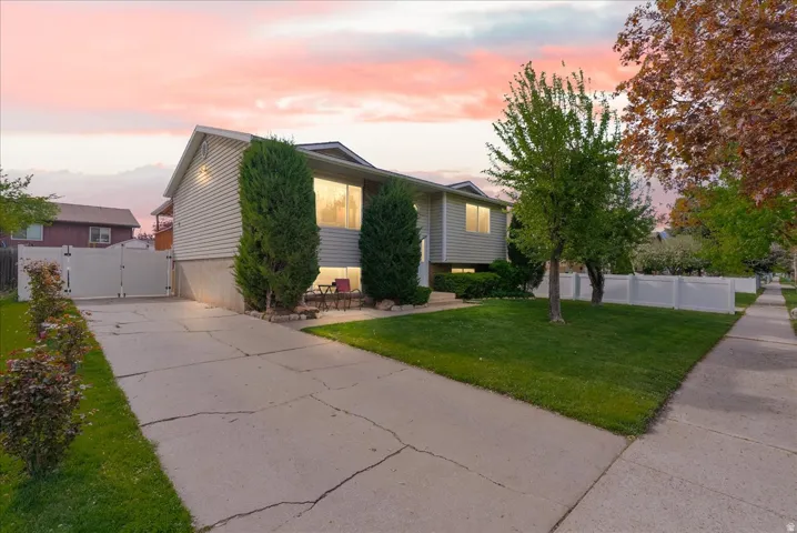 View of front of home featuring a gate, a patio, and driveway