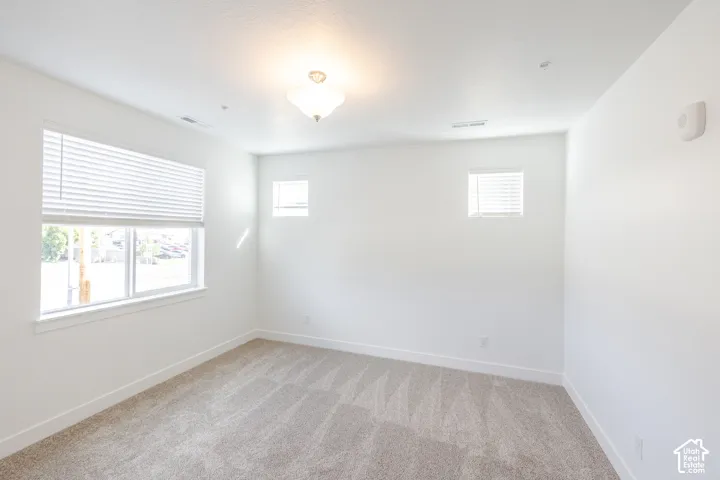 Neutral carpet flooring, white walls, and a semi-flush mount ceiling light fixture