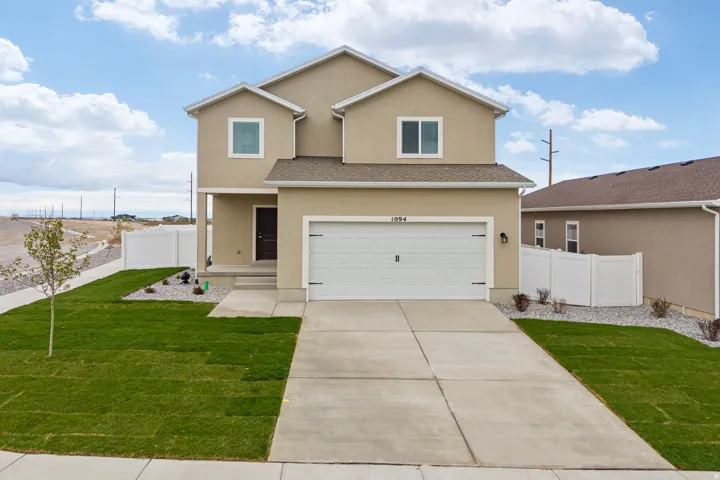 Contemporary stucco exterior featuring a two-car garage, concrete driveway, and front porch