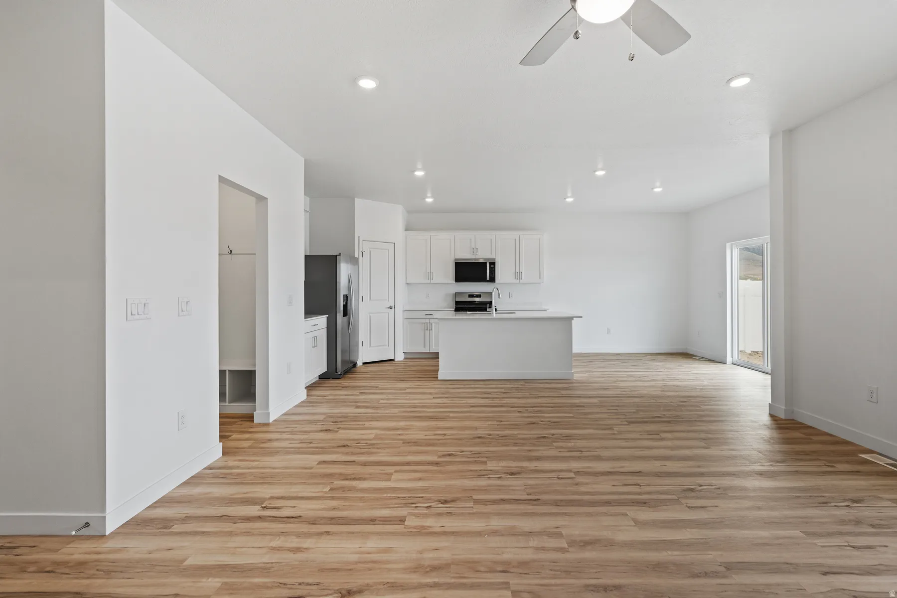 Expansive open-concept space featuring wood-finish flooring and recessed lighting