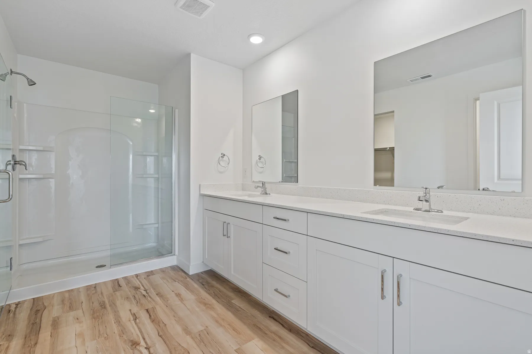 Contemporary bathroom featuring a dual vanity with white cabinetry, integrated sinks, and polished chrome faucets