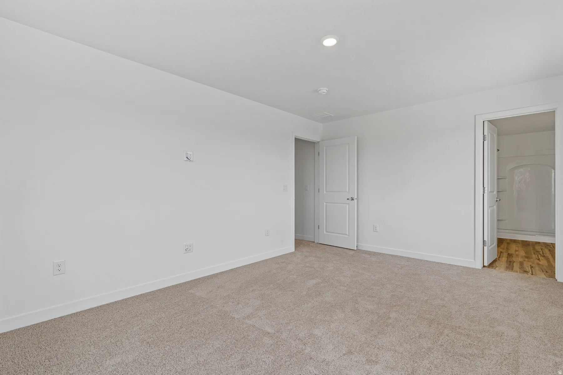 Neutral tone carpet flooring and white painted walls