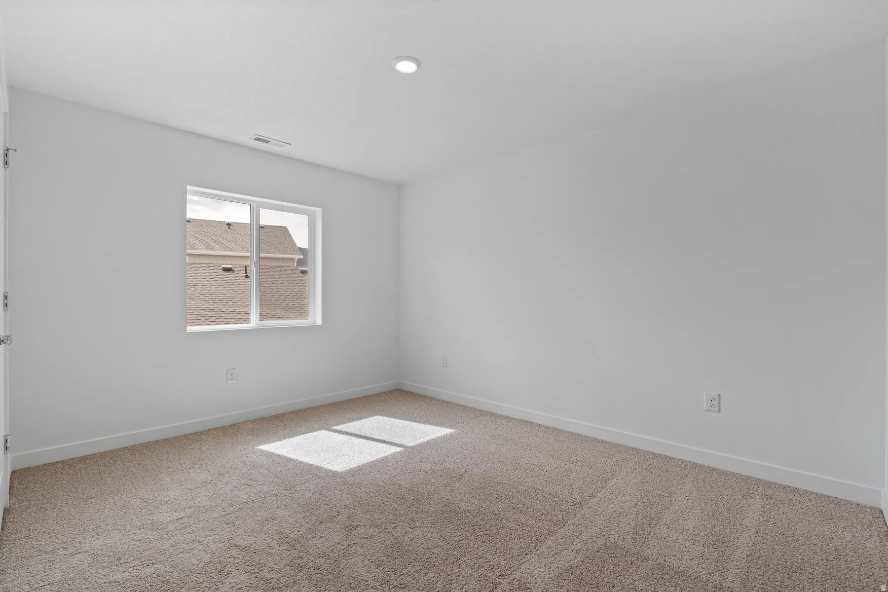 Carpeted room featuring a double-pane window, white walls, and a recessed ceiling light