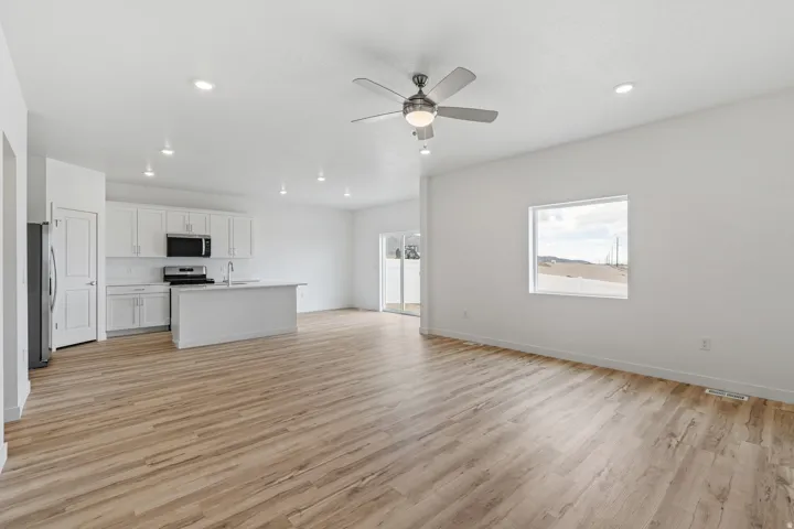 Open-concept living area featuring wood-finish flooring, recessed lighting, and a ceiling fan
