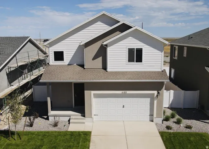 Two-story residence featuring a two-car garage, concrete driveway, and a covered entryway