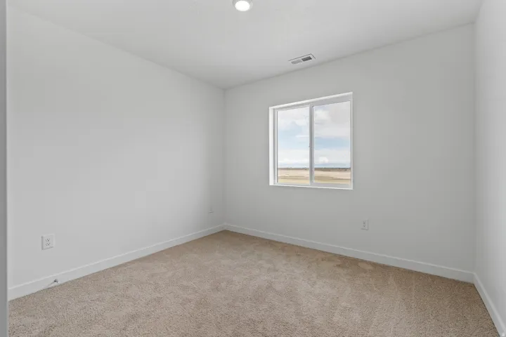 Carpeted room featuring a white single-pane window, white baseboards, and a recessed ceiling light