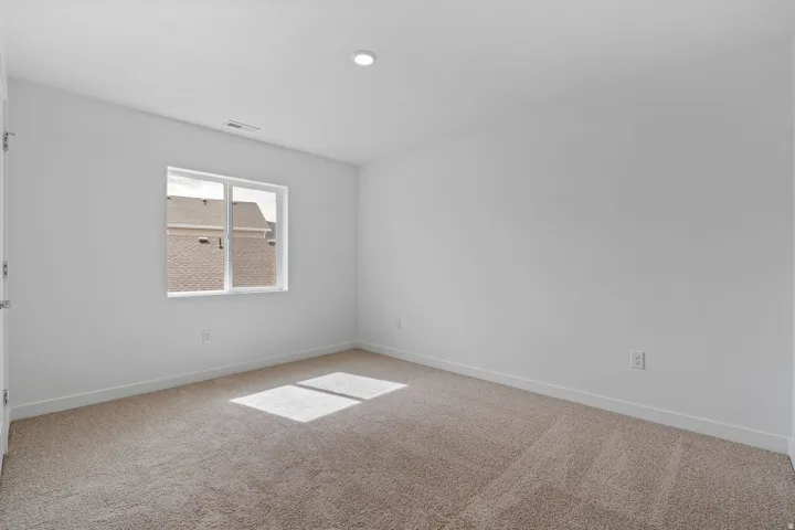 Carpeted room featuring a double-pane window, white walls, and a recessed ceiling light