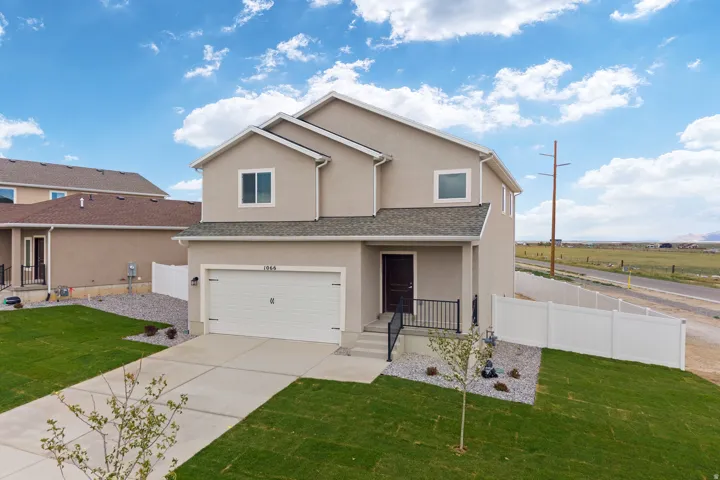 Contemporary two-story stucco residence featuring an attached garage and a covered front entry