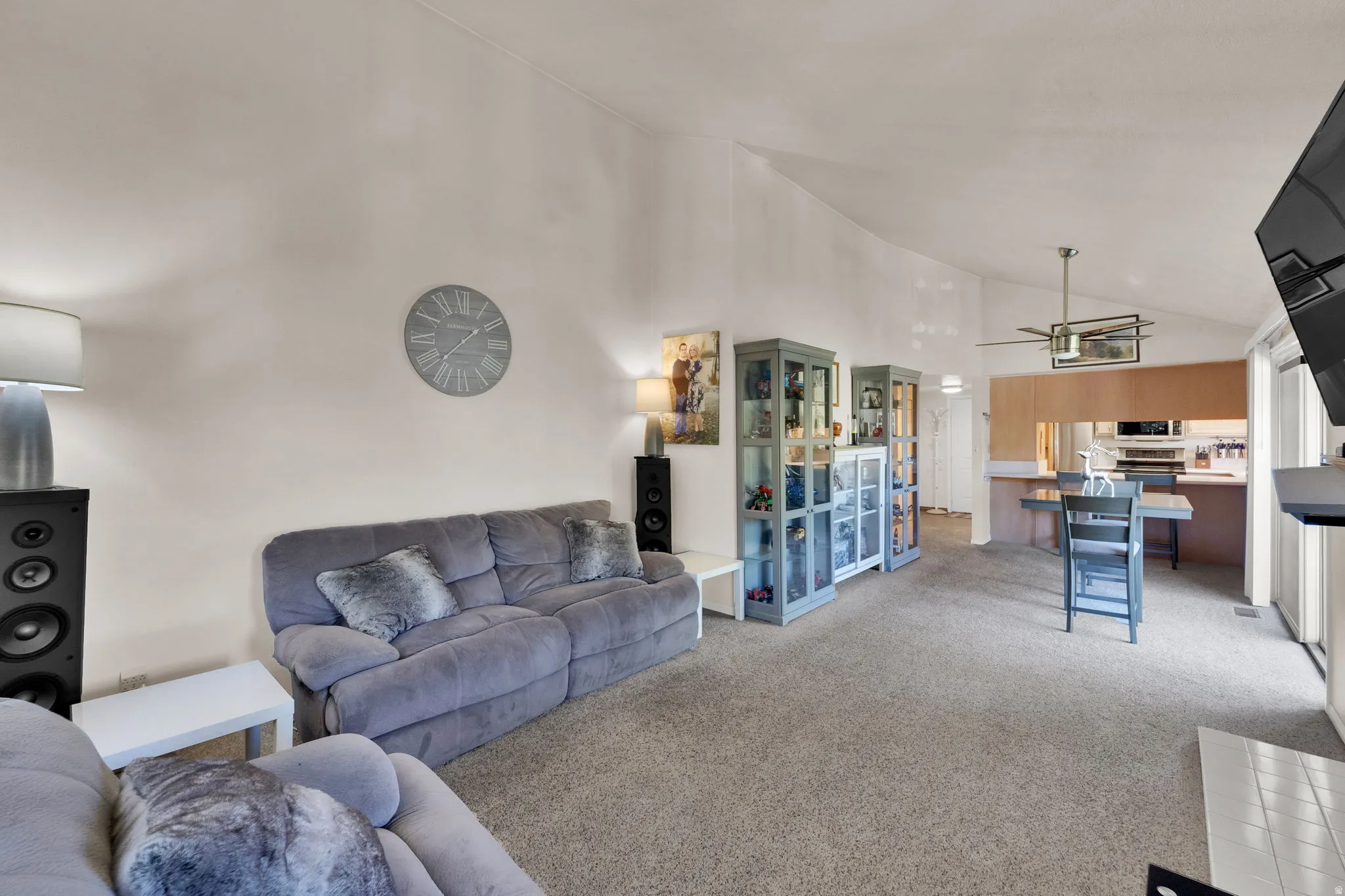 Living area with vaulted ceiling and light carpet