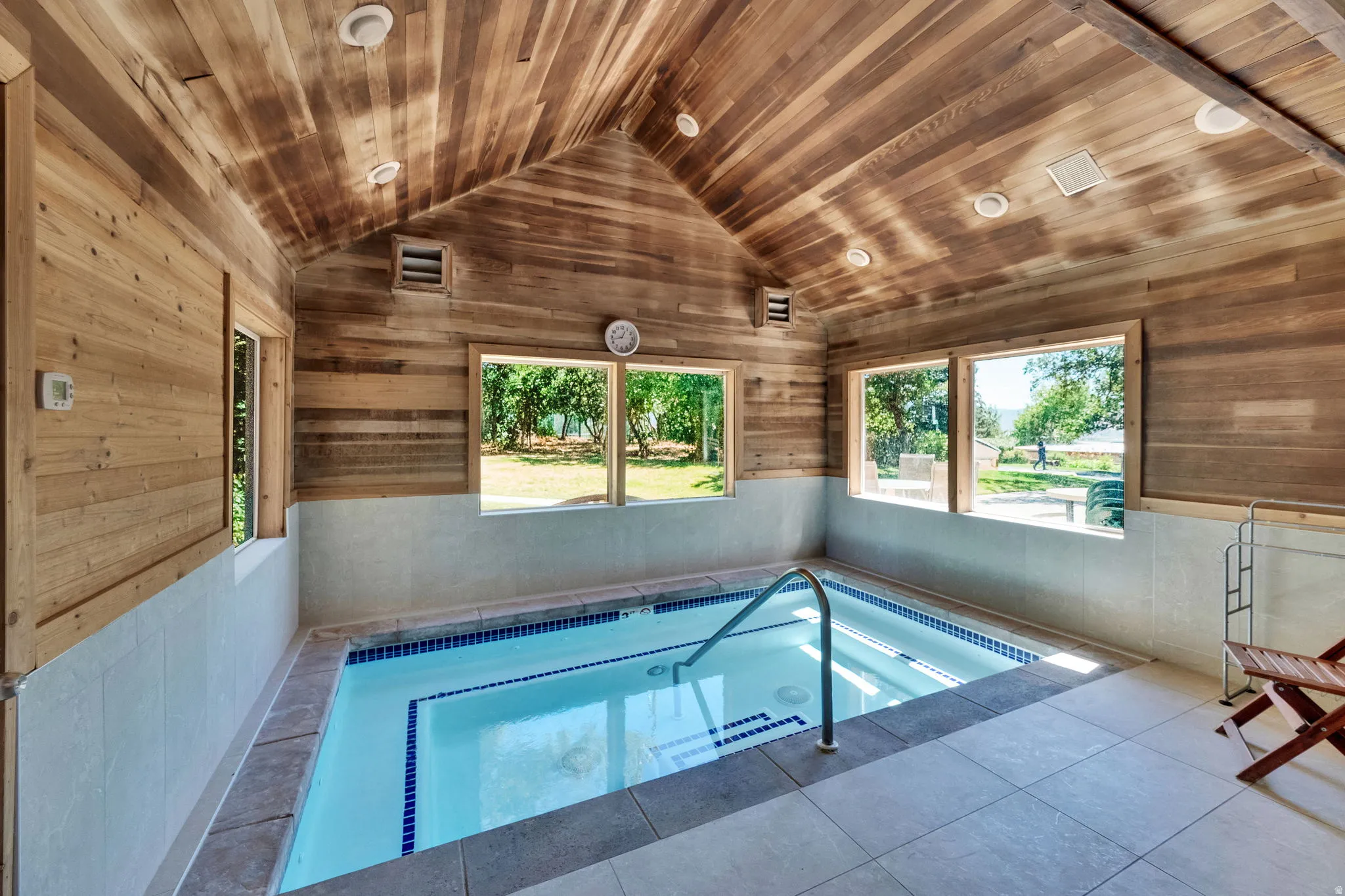 View of in-ground hot tub and a sunroom