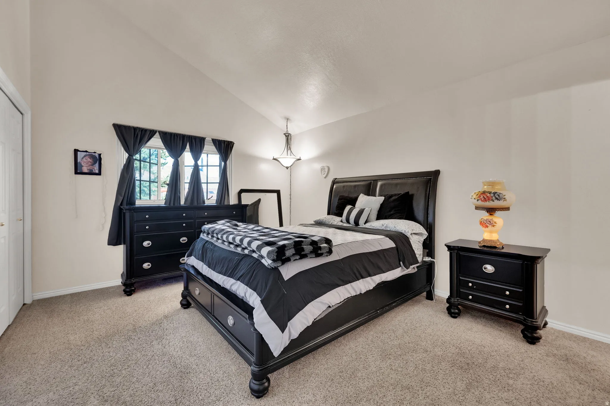 Bedroom featuring lofted ceiling and light carpet