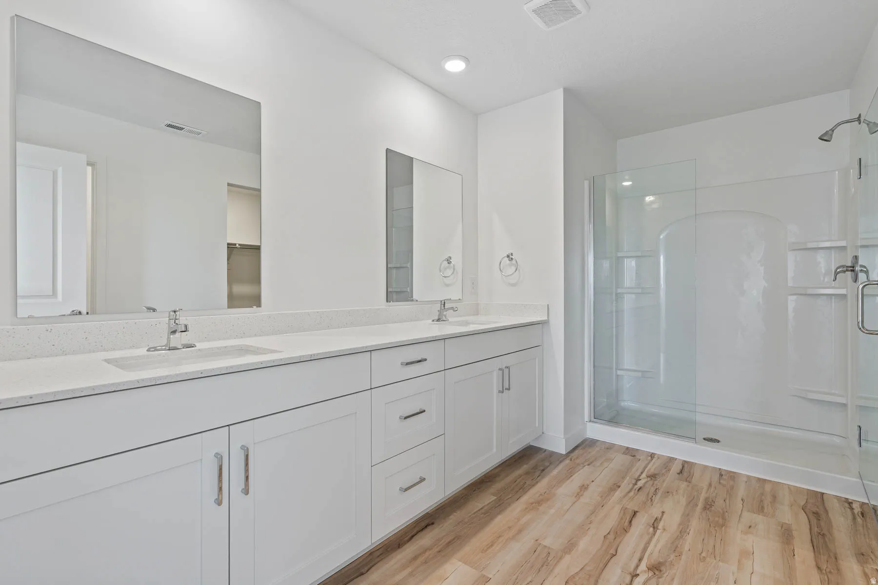 Contemporary bathroom featuring a double vanity with stone-look countertops and integrated sinks