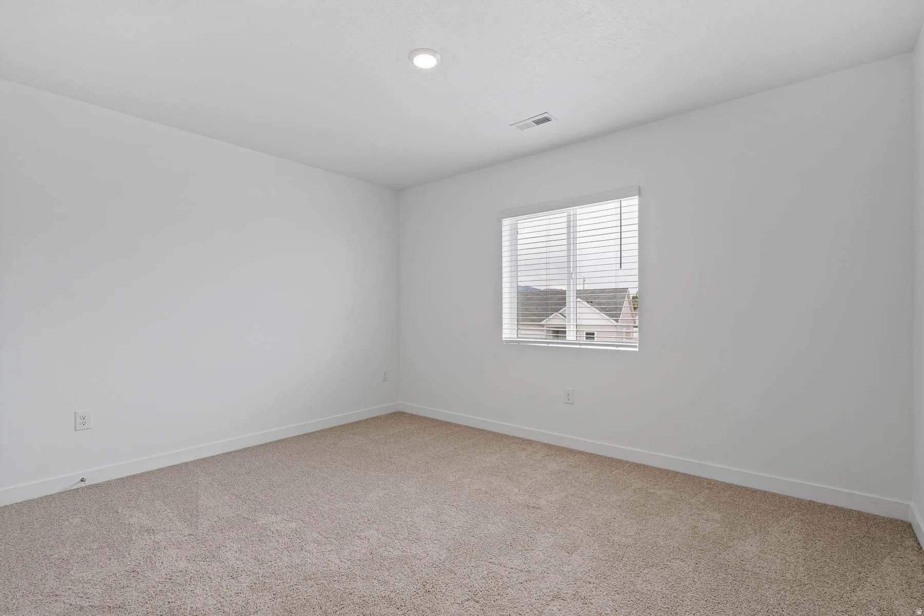 Neutral wall paint complements the carpeted flooring
