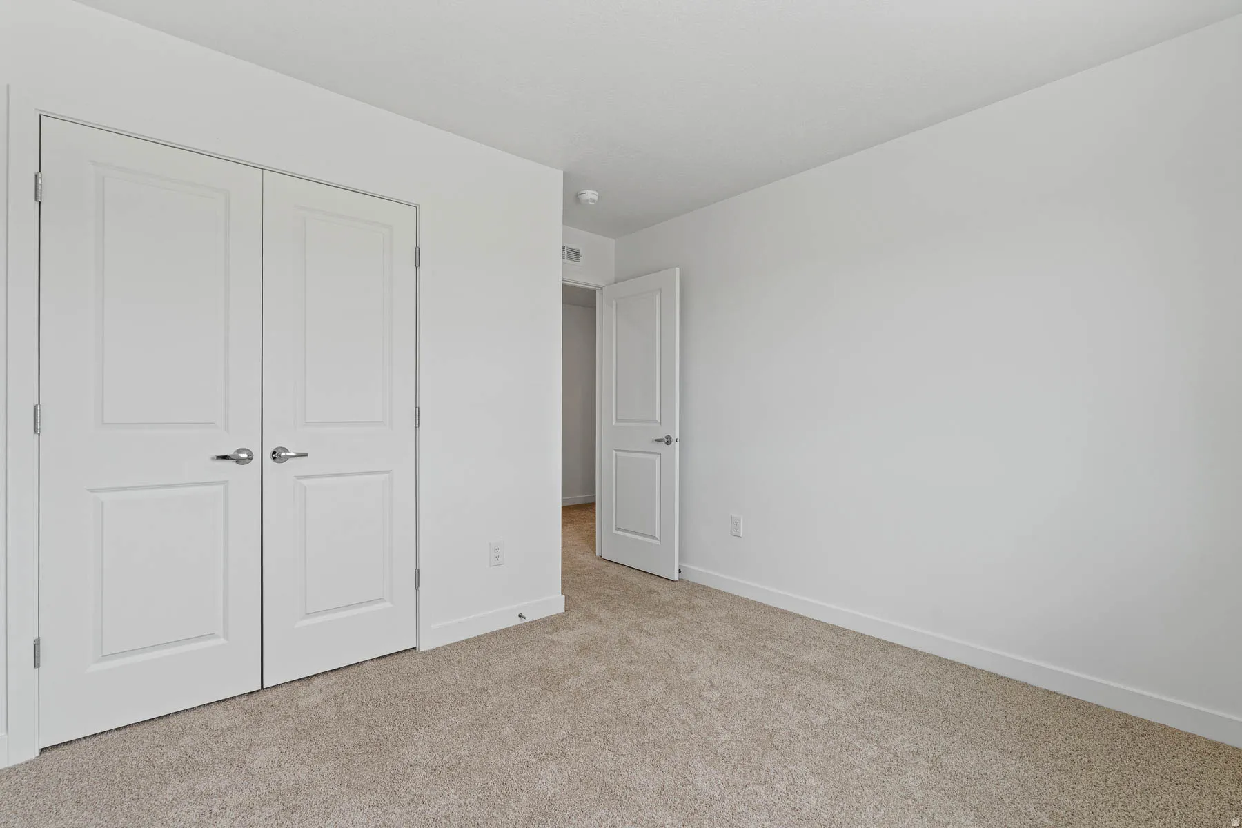 Neutral tone carpeting complements the white walls and trim
