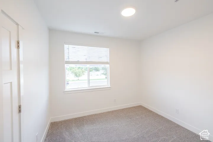 Neutral paint, recessed lighting, white trim, paneled door, and textured carpeting