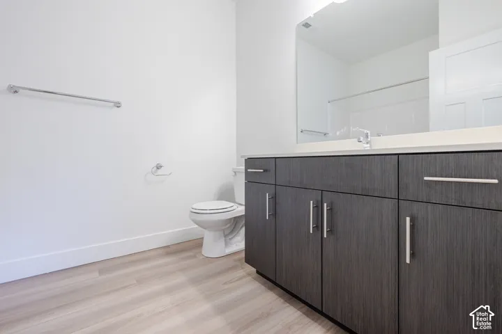 Vanity featuring a light-colored countertop, wood-finish cabinetry, and brushed nickel hardware