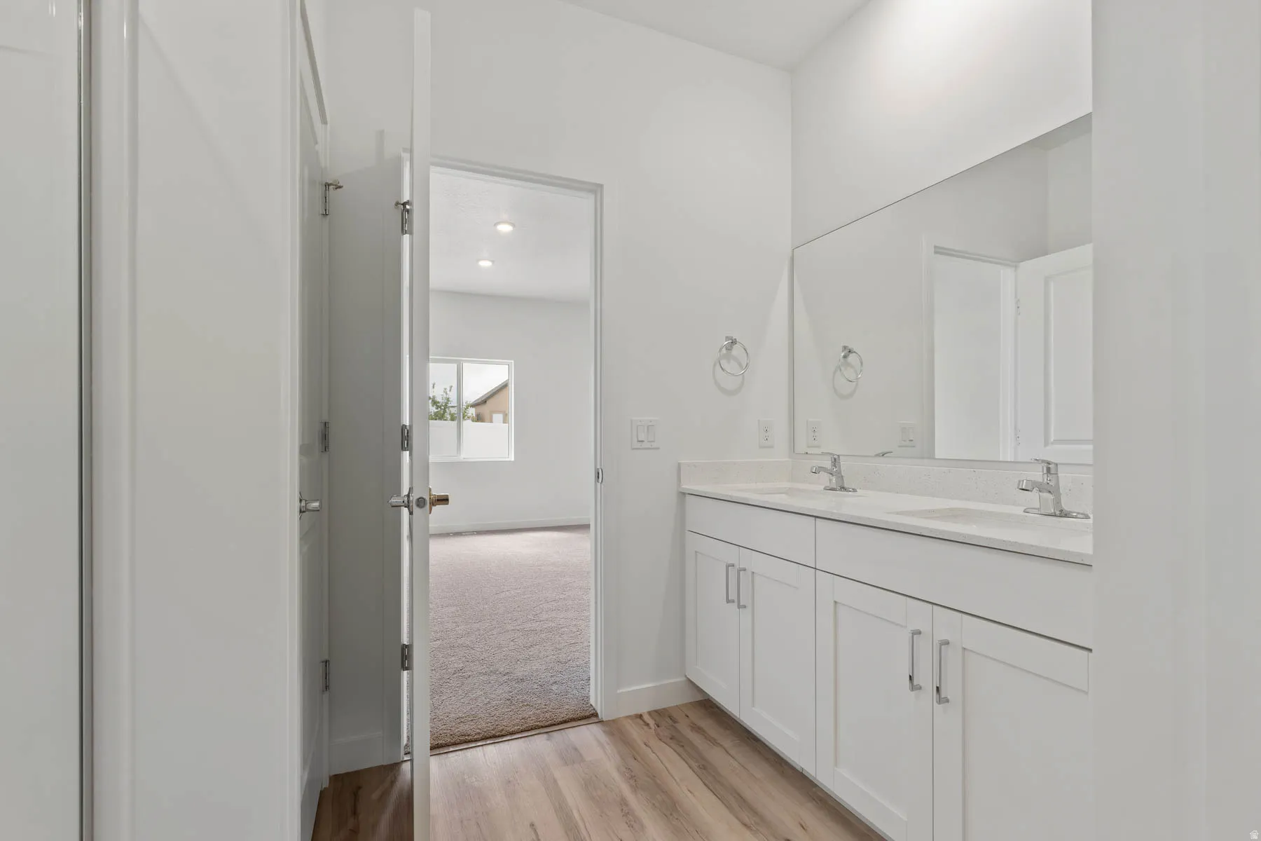 Dual vanity with white cabinetry, integrated sinks, and chrome faucets