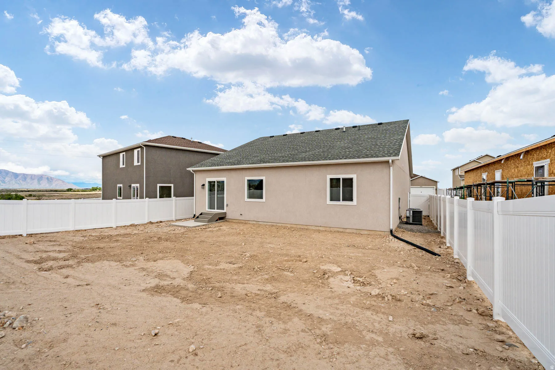 Expansive backyard area featuring a full vinyl privacy fence and a concrete patio