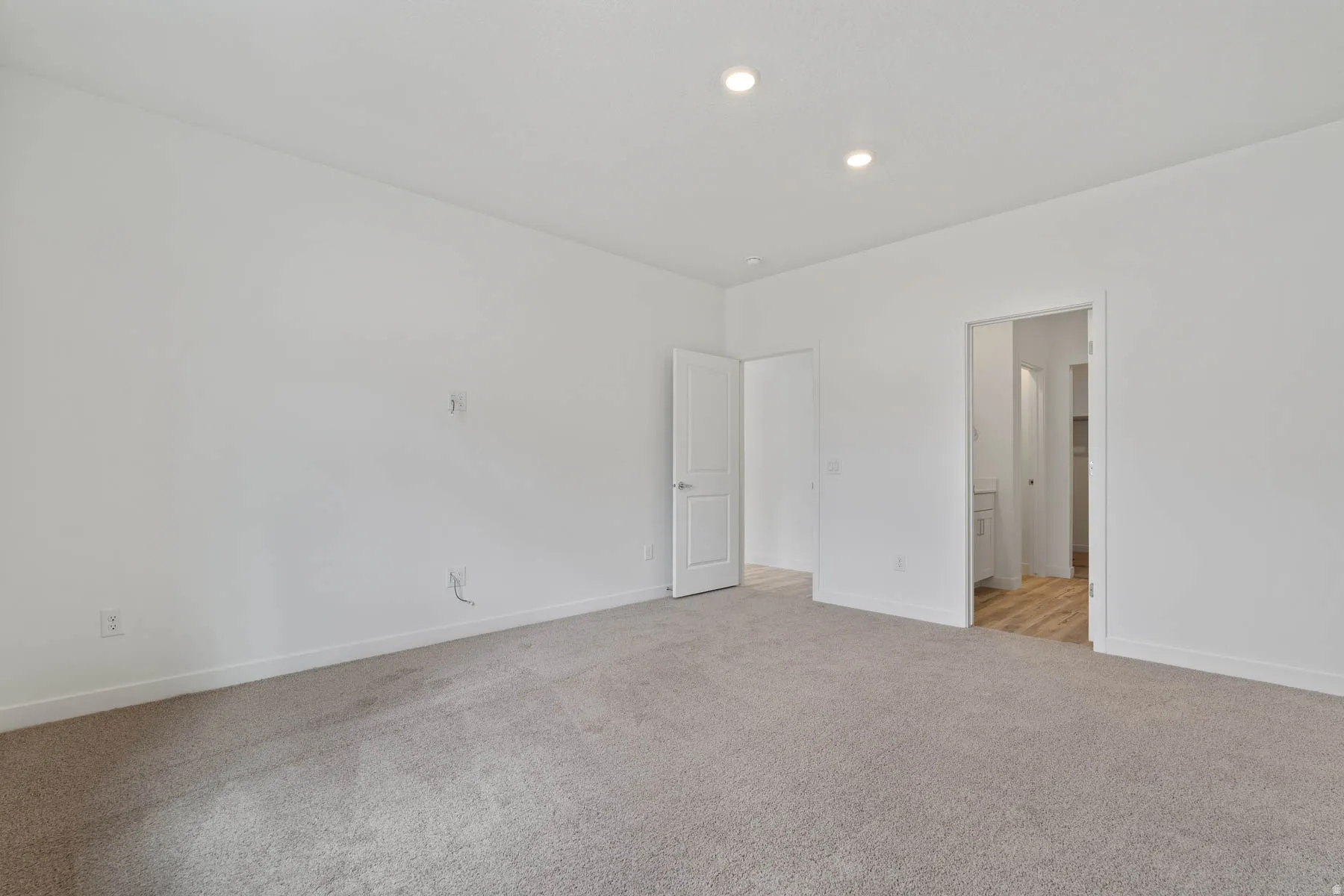 Spacious room featuring neutral carpeting and white wall finishes