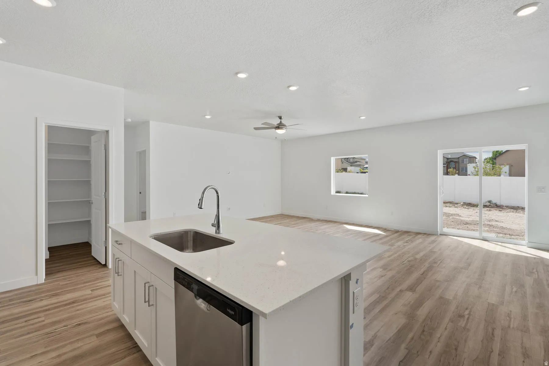 Central kitchen island with an undermount sink, gooseneck faucet, and integrated dishwasher
