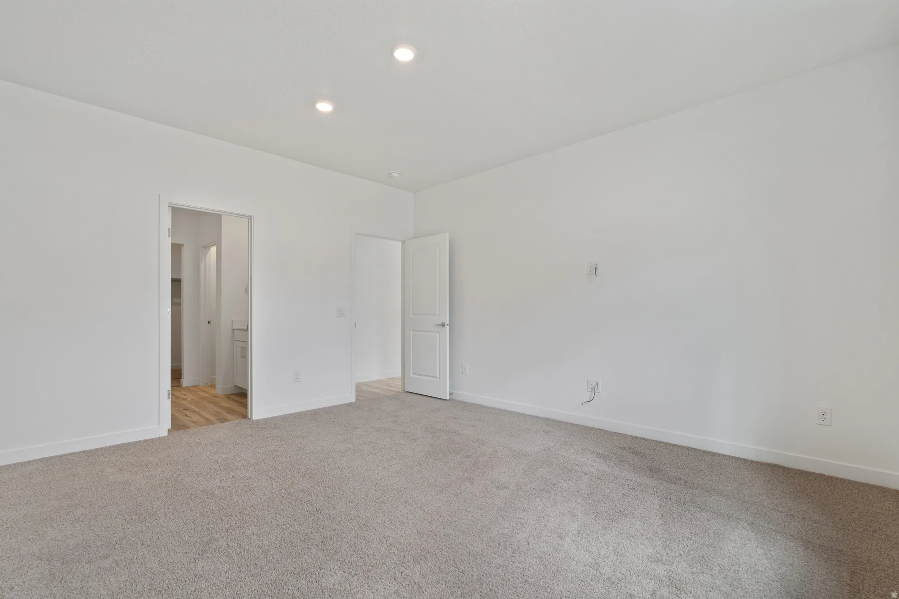 Spacious interior with neutral carpeting and recessed lighting