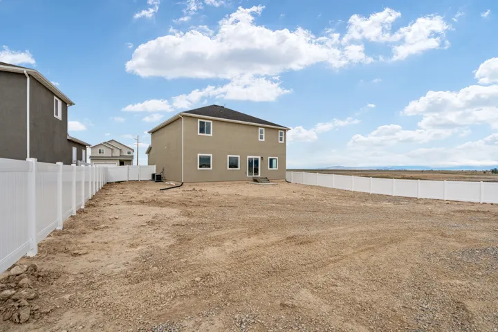 Expansive rear yard with a white privacy fence