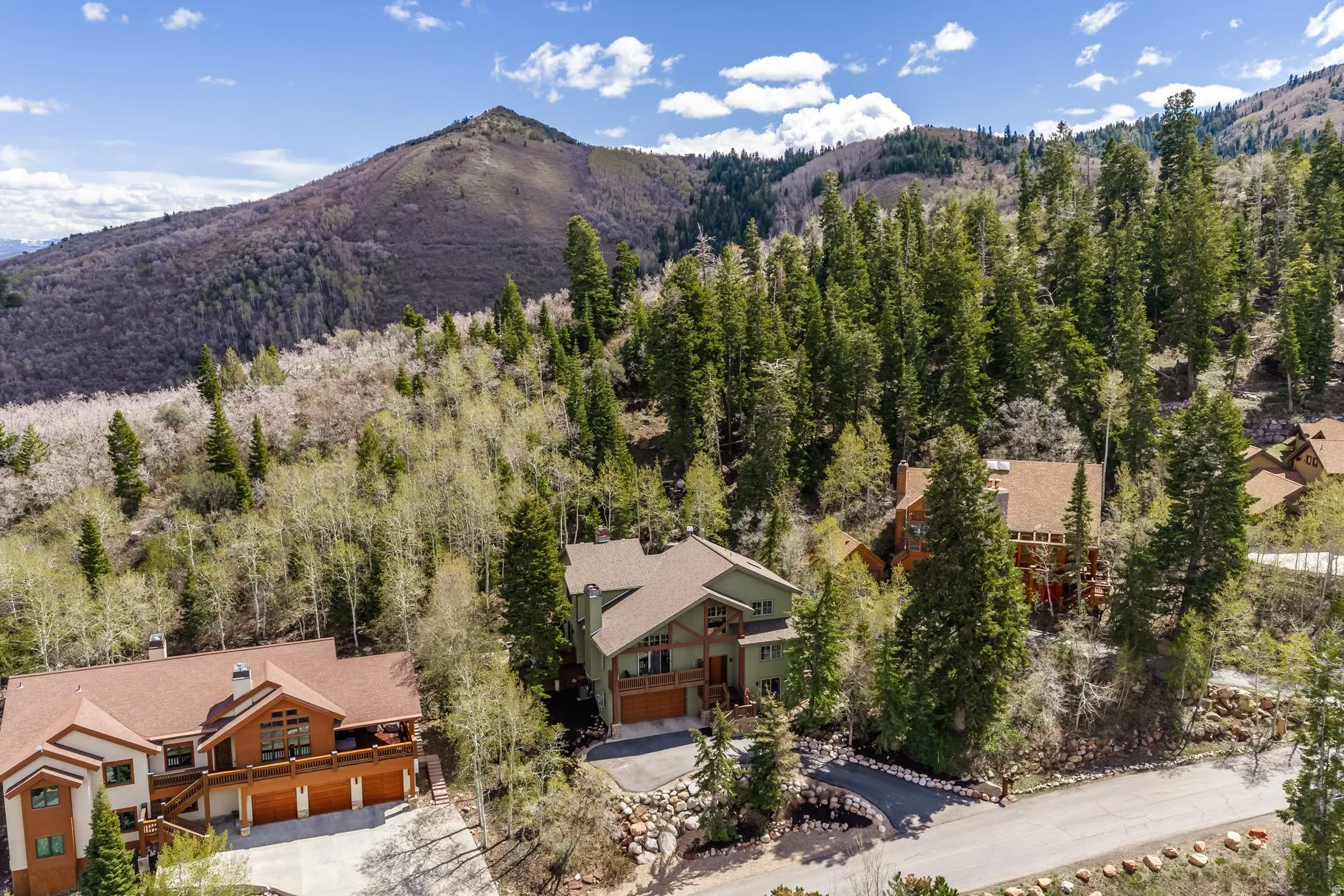 Mountain-side property featuring a multi-level structure with natural wood and siding details