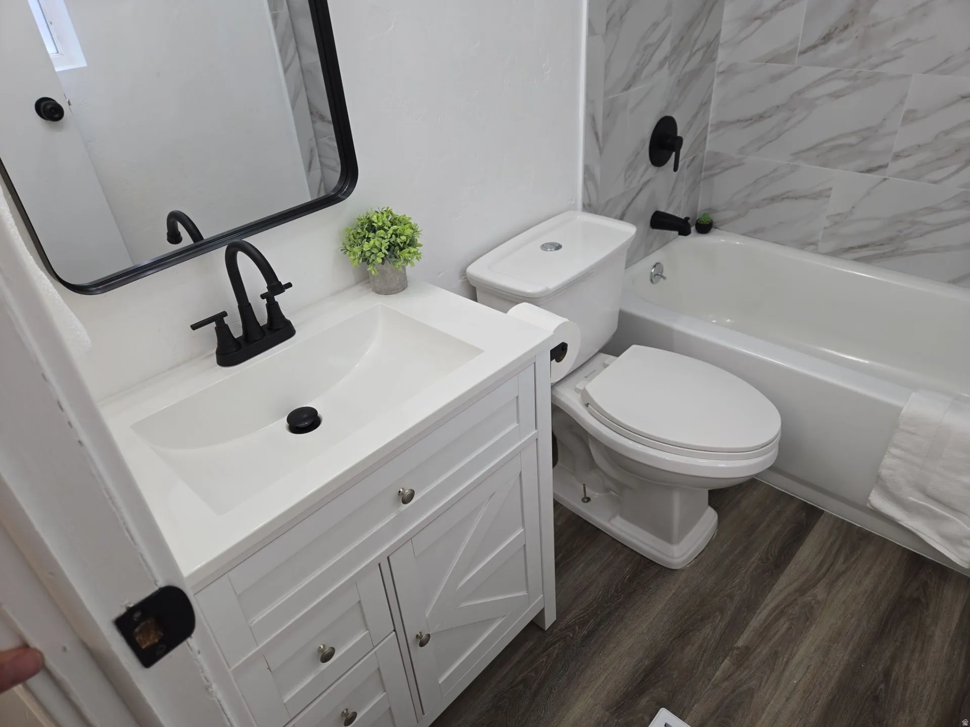 Full bath featuring vanity, dark wood-style floors, and shower / bath combination