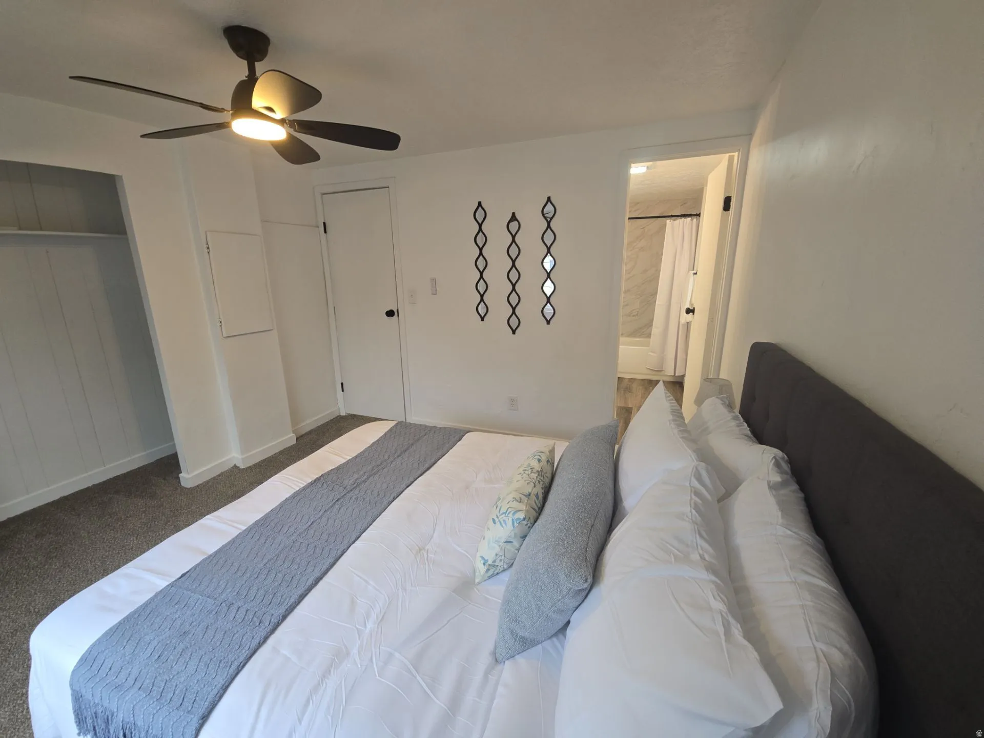 Bedroom with a ceiling fan, a closet, carpet floors, and connected bathroom