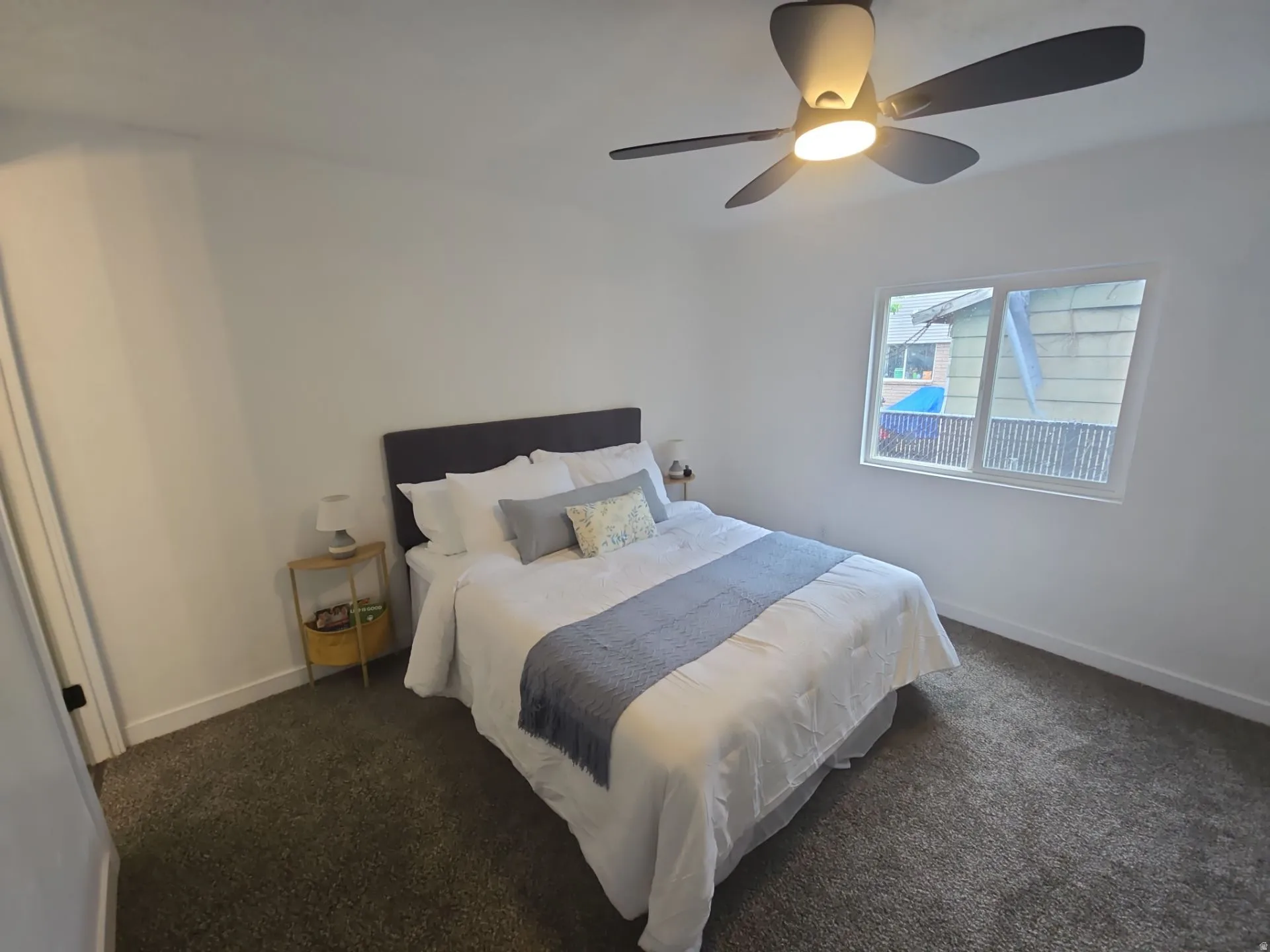 Bedroom with a ceiling fan and dark carpet