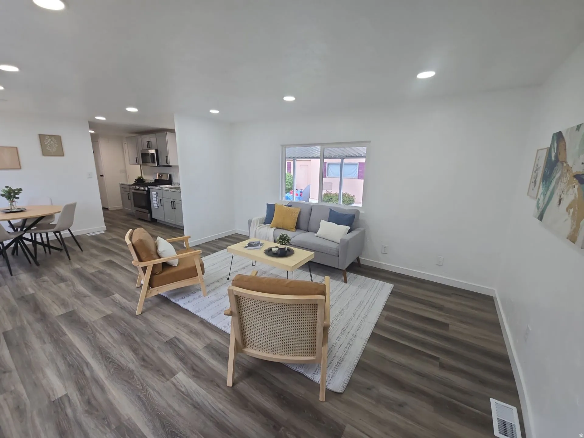 Living area with dark wood-type flooring and recessed lighting