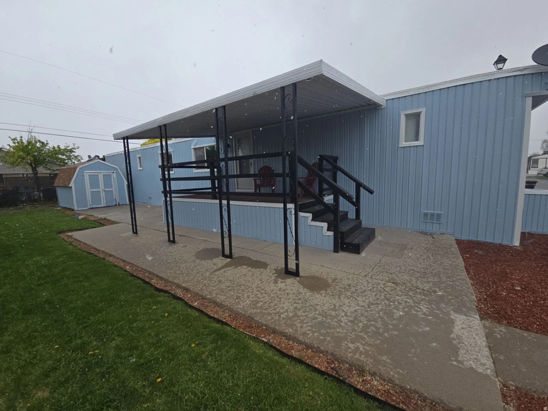 Rear view of house with a patio area, a lawn, and a storage shed