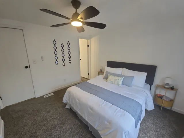 Bedroom featuring dark colored carpet and ceiling fan