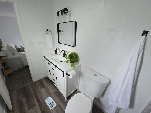 Ensuite bathroom featuring vanity and dark wood finished floors