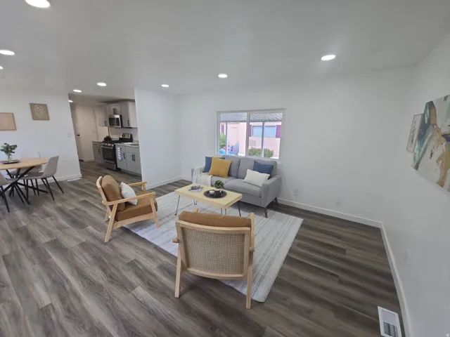 Living area with dark wood-type flooring and recessed lighting