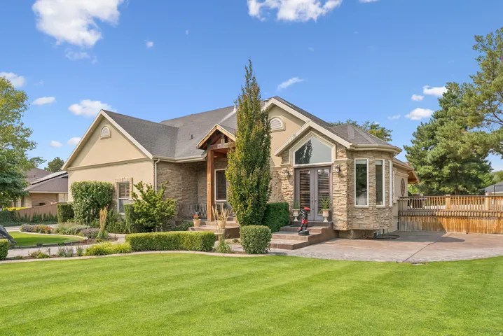 View of front of home featuring stone siding and stucco siding