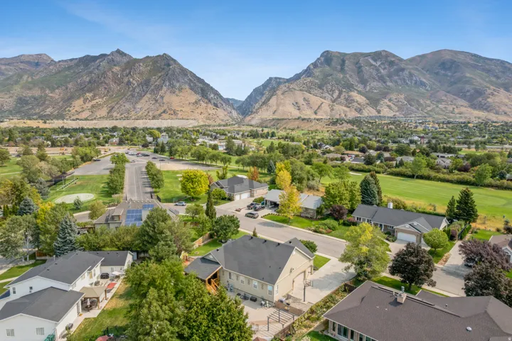 Aerial view of residential area with a mountainous background and a local golf course