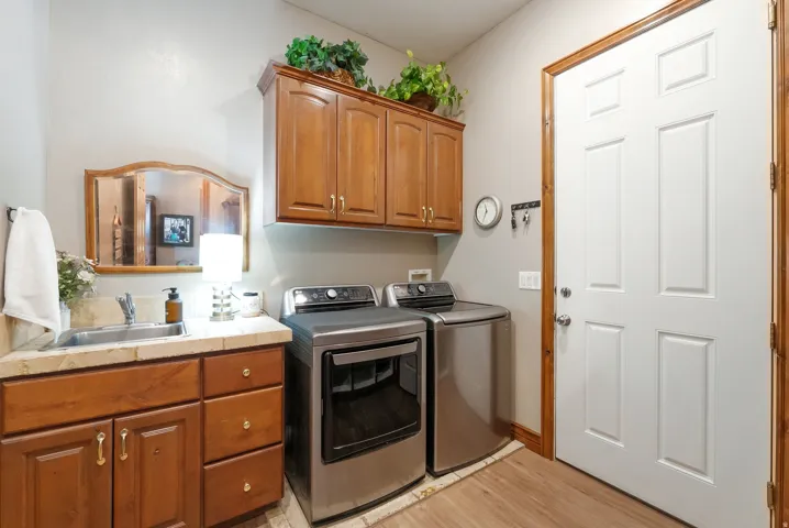 Laundry room with cabinet space, washer and clothes dryer, and light wood-type flooring