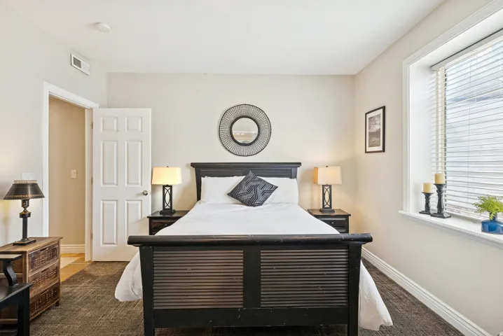 Bedroom with dark colored carpet and baseboards