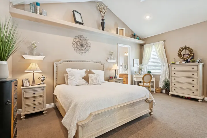 Carpeted bedroom with ensuite bath, vaulted ceiling, and recessed lighting