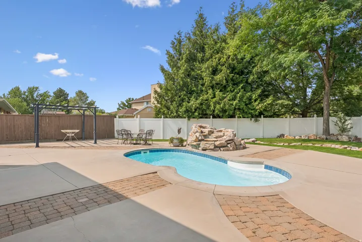 View of swimming pool with a fenced backyard and patio surround