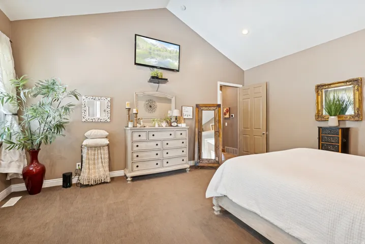 Bedroom with vaulted ceiling and carpet