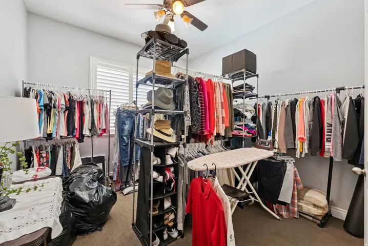 Walk in closet with a ceiling fan