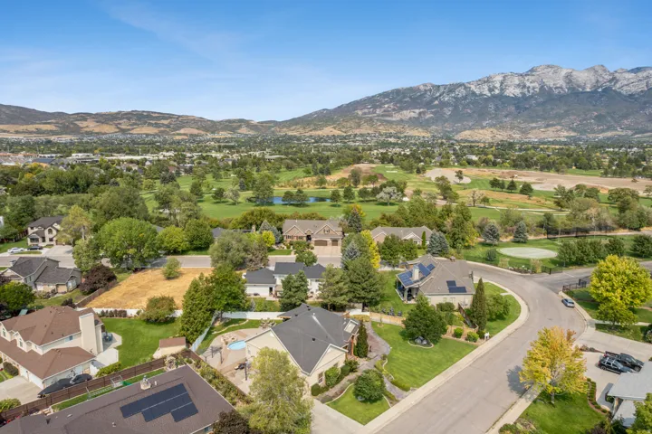 Aerial view of residential area with a water and mountain view and a golf course