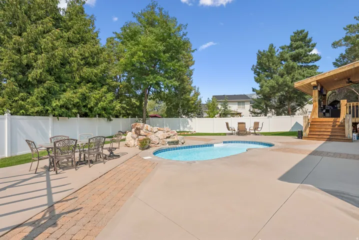 View of pool with patio surround, outdoor dining area, a fenced backyard, and a pool