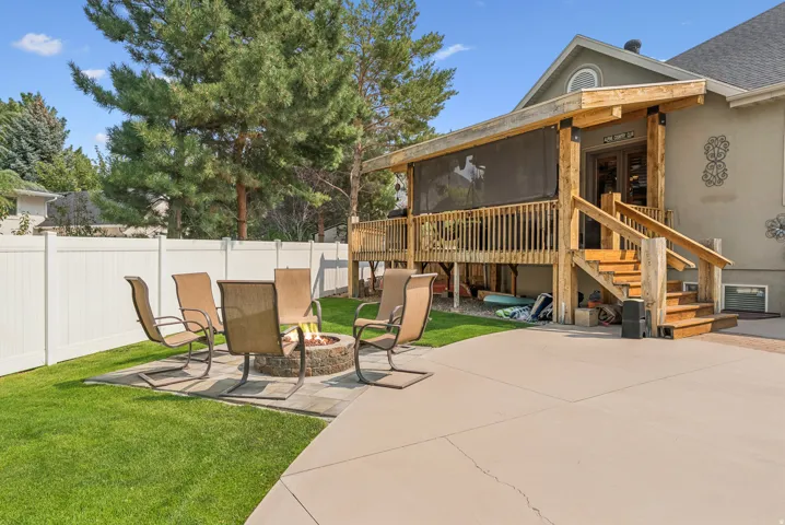 Fenced backyard featuring a patio area, an outdoor fire pit, and a sunroom