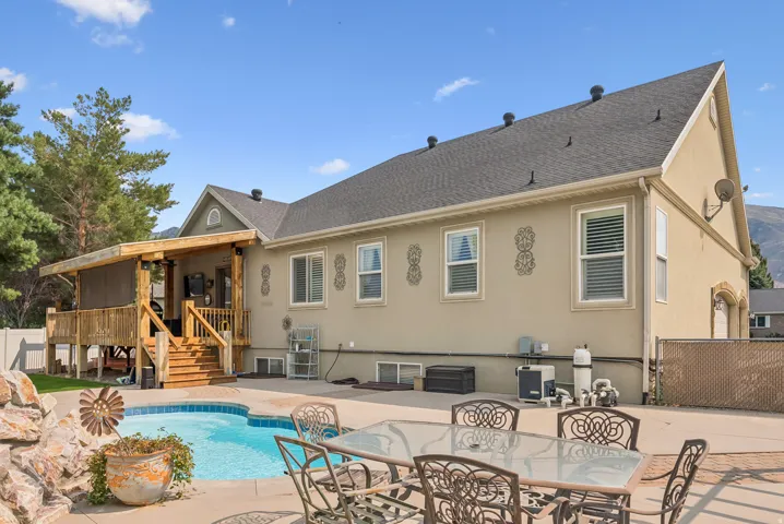 Back of property featuring a patio, stucco siding, and a shingled roof